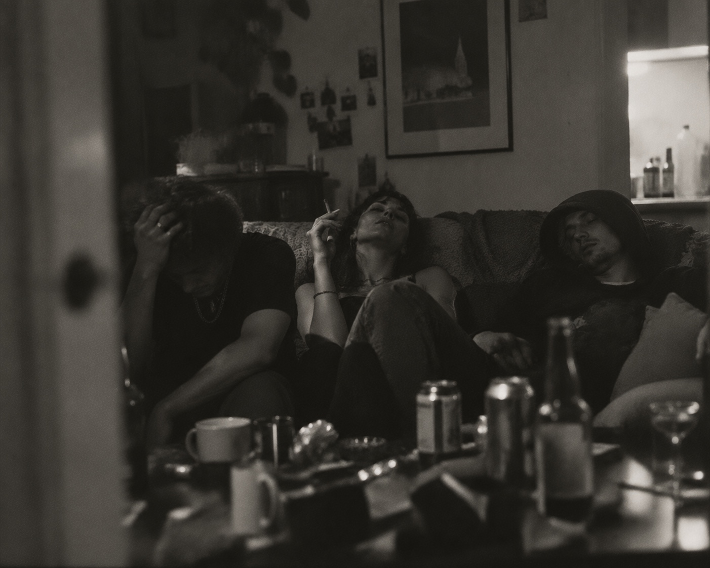 Three people on a sofa in a dim room