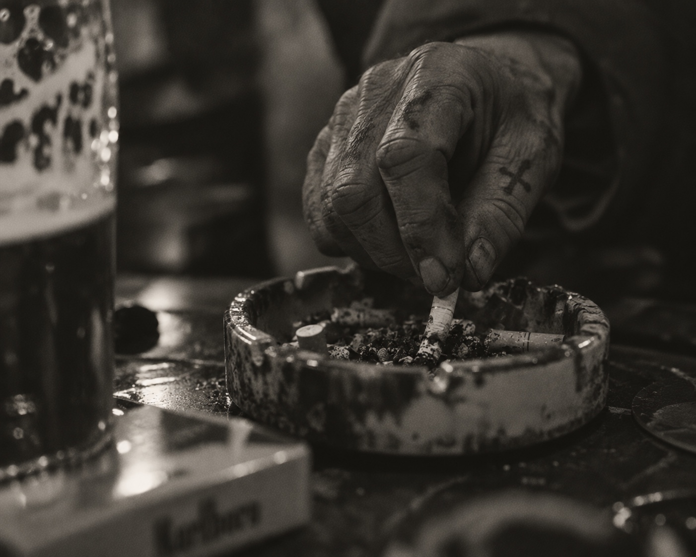 Close-up of a hand putting out a cigarette in an ashtray