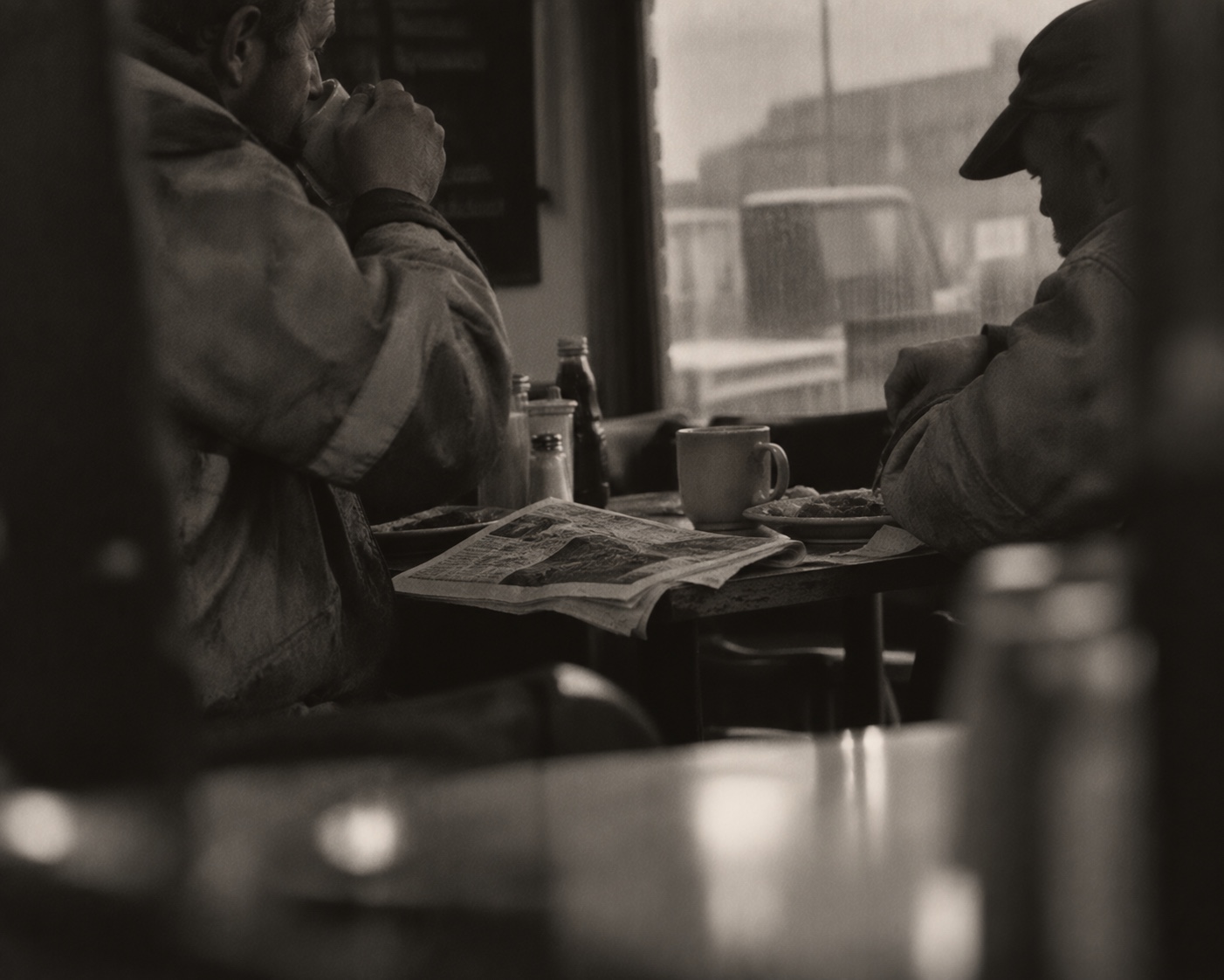 Two men sitting in a cafe with a newspaper