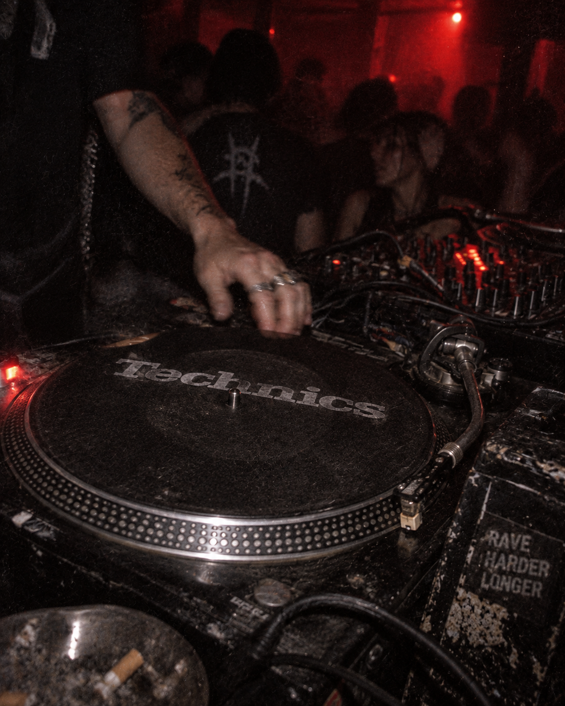 Close view of a hand on a Technics turntable in a club booth