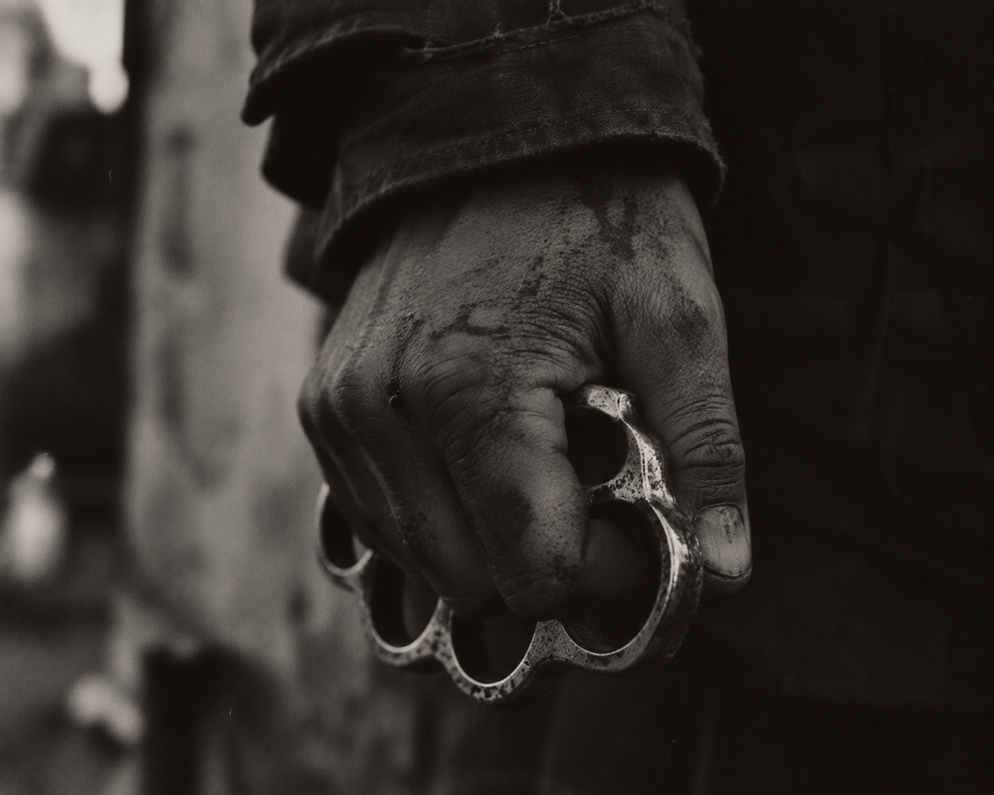 Close-up of a clenched fist holding brass knuckles