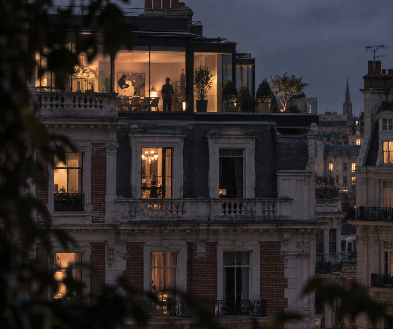 Paris rooftop apartment with a brightly lit glass extension and distant skyline