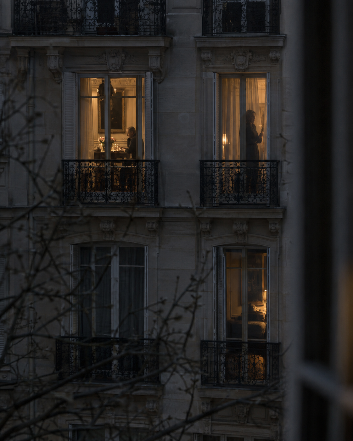 Two neighbouring Paris windows lit warmly, each showing a different solitary figure
